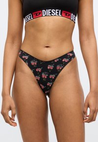 Mustad tangadega aluspüksid kirsi kujundusega, millel on laineline serv ja Diesel'i logo vöökoht. Pehme puuvillane materjal.
