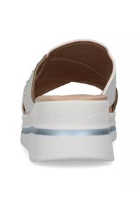 Sandalo bianco open-toe con materiale testurizzato, soletta imbottita color nocciola e tacco basso a cuneo con un sottile accento blu attorno alla suola.