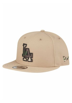 Beżowa czapka snapback z czarnym haftem "LA", płaskim daszkiem i akcentem w kamuflażu po boku. Wykonana z teksturowanej tkaniny.