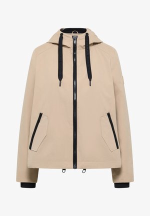 Veste à capuche beige avec une fermeture éclair noire, deux poches avant zippées, cordons noirs avec texte, et poignets intérieurs noirs.