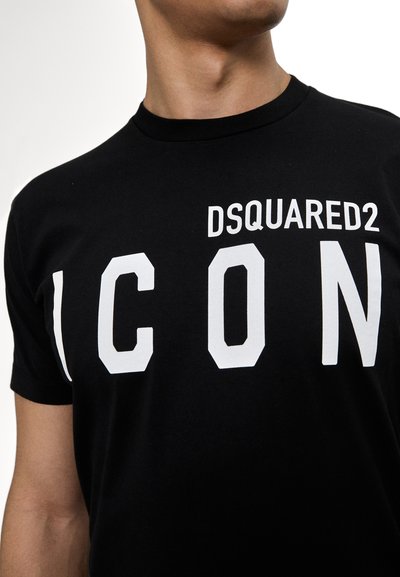 Must must särg mustast puuvillast, millel on julged valged "DSQUARED2 ICON" kirjatrükk, lühikesed varrukad ja ümmargune kaelus. Minimalistlik disain klassikalise lõikega.