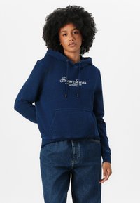 Haut court bleu marine en tissu doux, avec une poche avant, un capuchon à cordon et un logo brodé blanc sur la poitrine.
