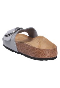 Sandale à glissière en vernis gris avec une semelle en liège, dotée d'une large sangle et d'accents métalliques. Semelle texturée pour une meilleure adhérence. Ajustement réglable.