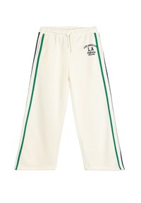 Pantalones de chándal color crema con franjas laterales en verde y azul marino, cinturilla elástica y detalle de texto "Los Ángeles L.A. California Desde 1990".