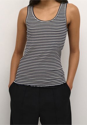 Débardeur rayé bleu marine et blanc avec texture côtelée, encolure arrondie et ourlet festonné, associé à un pantalon noir taille haute.