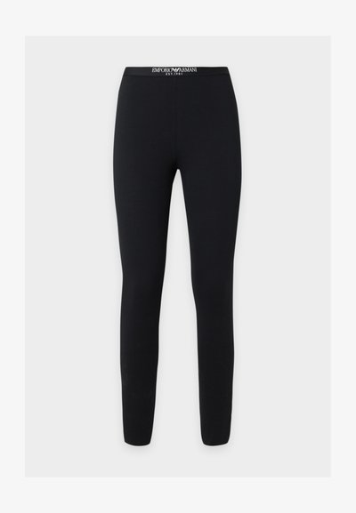 Leggings noirs ajustés avec un texte blanc sur la ceinture de marque Emporio Armani, affichant le logo et "EST. 1981" sur un fond uni.
