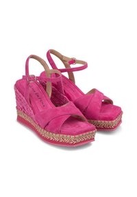 Sandales compensées en daim rose vif avec des lanières croisées et une boucle à la cheville. Plateforme en jute avec un accent texturé. Design à bout carré.