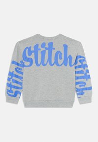 Világosszürke pulóver, nagy kék "Stitch" felirattal a háton és mindkét ujjon, vastag dőlt betűvel.