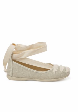 Ballerines en toile beige avec un dessus texturé, des brides croisées décoratives et un bout arrondi, dotées d'une semelle flexible.