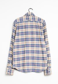 Camisa de cuadros de manga larga con un patrón azul, crema y rojo. Presenta un cuello clásico, botones en los puños y un dobladillo curvado.