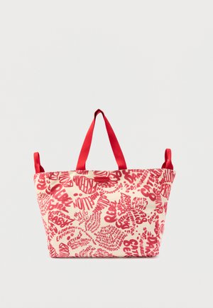 Bolso de mano color crema con texto abstracto rojo y asas rojas sobre fondo blanco.