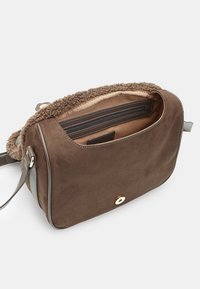 Borsa a tracolla in suede marrone con rifiniture simili a pelliccia morbida. Presenta una tasca interna con zip, accenti grigi lisci e una chiusura metallica circolare.