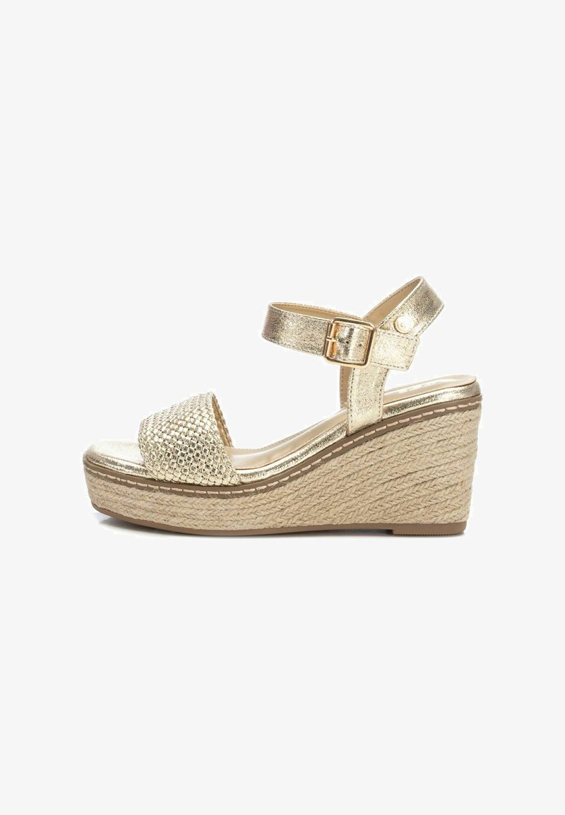 Sandalias cuña doradas con un upper metálico texturizado y plataforma de yute trenzado. Una correa en el tobillo ajustable cuenta con un detalle de hebilla.
