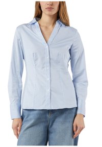 Light blue striped button-up shirt featuring a pointed collar, long sleeves, front button closure, and tailored fit. Classic design and smooth texture.