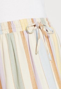 Randet nederdel med pastelfarver såsom lys blå, gul, grøn og beige. Elastisk talje med snoretræk for justerbar pasform.