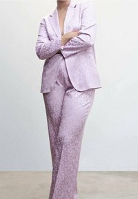 Light purple suit with polka dot texture, featuring a single-breasted blazer and straight-leg trousers, made of smooth fabric.