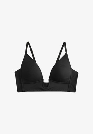 Kvinde med en sort dyb V-hals bralette med tynde stropper og bred underbånd, som viser mave og skuldre.