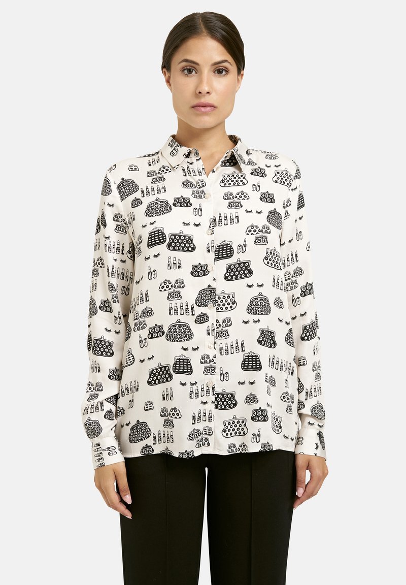 Long-sleeve blouse in cream fabric featuring black illustrated patterns of various objects, with a button-down collar and cuffs.