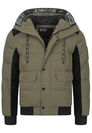 Giacca imbottita verde oliva con dettagli in corduroy nero, cappuccio regolabile con coulisse, chiusura con zip, tasche a toppa e polsini a coste. Superficie testurizzata.