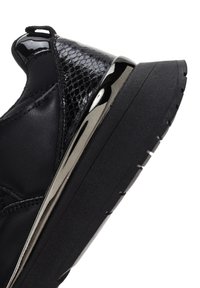 Sneaker nera con tomaia in vernice lucida, pannello laterale testurizzato, dettagli riflettenti e suola in gomma spessa con battistrada.