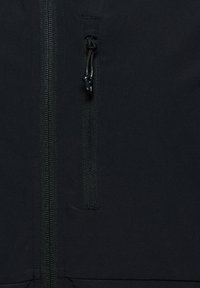 Nahaufnahme einer schwarzen Jacke mit einer vertikalen Reißverschlusstasche mit Zugkordel und einer Hauptreißverschlussnaht daneben.