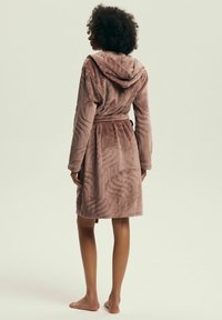 Hooded bathrobe in soft, textured mauve fabric featuring wavy pattern details, cinched waist with a tie, and mid-thigh length.