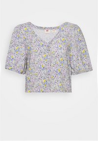 Blouse courte à manches courtes avec décolleté en V, manches bouffantes et un motif floral jaune, violet et bleu sur fond blanc.