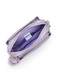 Lila Kipling-Täschchen mit geöffnetem Hauptreißverschluss, das zwei Fächer, ein Innenetikett und einen befestigten, flauschigen Schlüsselanhänger zeigt.