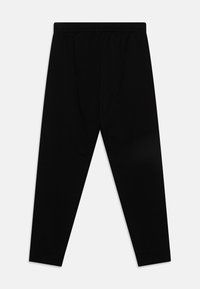 Schwarze Baumwollhose mit elastischem Bund, schmal zulaufenden Beinen und elastischen Bündchen an den Knöcheln. Glatte Textur ohne erkennbare Muster oder Akzente.