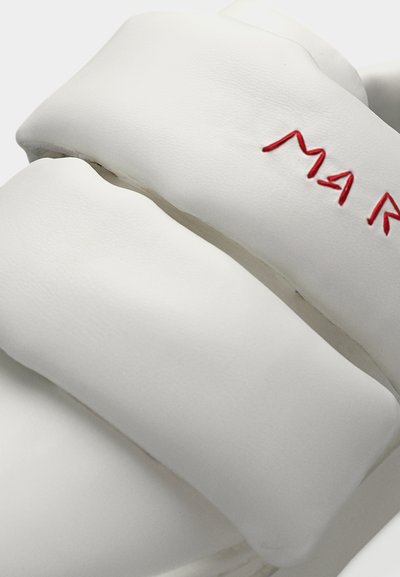 Άσπρα σανδάλια από αφρώδες υλικό με φαρδιές λουρίδες και ανάγλυφα κόκκινα γράμματα "MAR". Λείο υλικό με μινιμαλιστικό σχέδιο και στρογγυλεμένες μορφές.