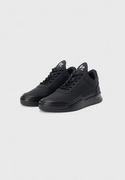 Μαύρα αθλητικά παπούτσια με επάνω μέρος από δίχτυ, διακοσμημένη διάτρητη σχεδίαση, επίπεδα κορδόνια και υφή στη σόλα από καουτσούκ. Διαθέτουν λογότυπο στη γλώσσα.