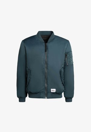 Teal värvi bomber-jakk, millel on lukuga eesmine sulgur, soonikuides varrukad ja kaks küljetaskut. Esiküljel on vasakul varrukal fläpptasku. Sile ja läikiv materjal.