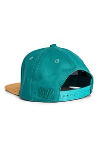 Gorra de tela en color azul verdoso con visera de gamuza color beige, con un diseño de concha bordado en la parte trasera y cierre ajustable a presión.