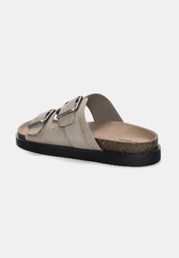 Beige ruskinds slidesandal med to justerbare spænder, en korkfodnote og en struktureret sort gummisål for greb og komfort.