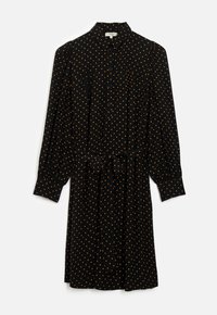 Zwarte jurk met lange mouwen, knoopsluiting aan de voorkant en oranje stippen. Voorzien van een ceintuur in de taille en een klassiek kraagontwerp.