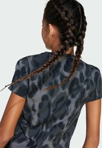 T-shirt a maniche corte di colore grigio scuro con stampa leopardata nera, realizzato in tessuto morbido; presenta un collo rotondo e una vestibilità rilassata.