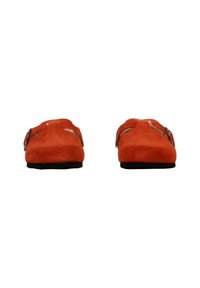 Zapatillas de ante rojo con suela plana, que cuentan con dos hebillas ajustables y una textura suave. El diseño es minimalista y de tipo slip-on.