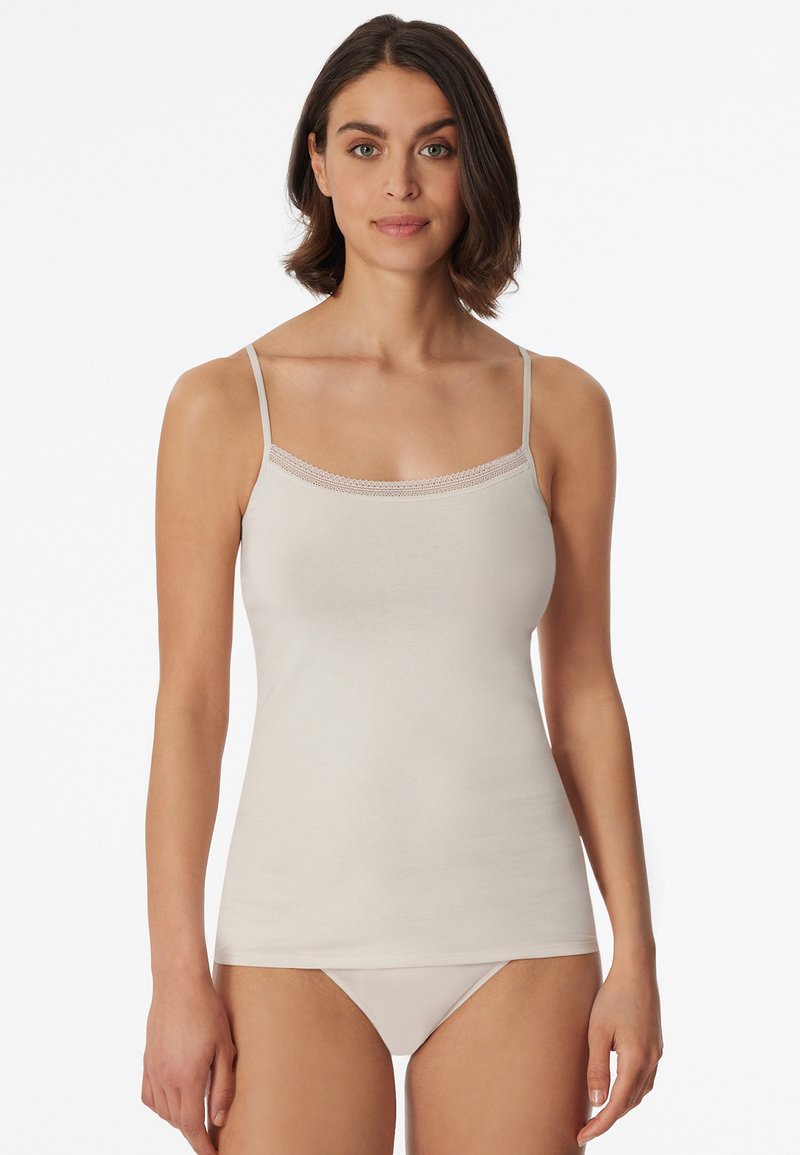 Beige camisole with thin adjustable straps, featuring a delicate lace trim along the neckline, made of soft, smooth fabric.