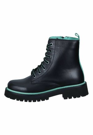 Black leather combat boot with green trim, green laces, and chunky black sole, shown in side profile on white background.