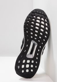 Černá sportovní podrážka se strukturovaným gumovým gripem, obsahující kruhové vzory a bílou mezipodešev. Viditelné logo "Continental".