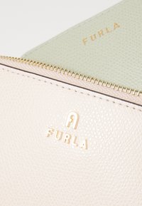 Furla lommebok i myk rosa og grønn teksturert lær med gulllogo-detalj, som har glidelås og kontrastfarget innside.