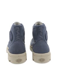 Μπλε καμβαδάκια ankle με μπεζ καουτσούκ σόλες. Διαθέτουν στρογγυλή μύτη, υφή υφάσματος και μια έντονη λογότυπη ταμπέλα στα πλάγια.