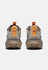 Bruine en beige wandelschoenen met een gestructureerde bovenkant, oranje trekband en robuuste zool. Voorzien van een logo op de hak en duurzame materialen.