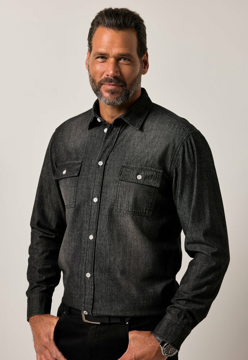 Camicia in denim nera con maniche lunghe, due tasche sul petto, chiusura frontale a bottoni e bottoni bianchi; presenta una vestibilità classica e una leggera texture.