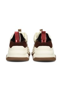 Baskets de sport avec un dessus crème, des accents en daim marron, des languettes de talon rouges métalliques et une semelle texturée marron. Dotées de panneaux en maille.