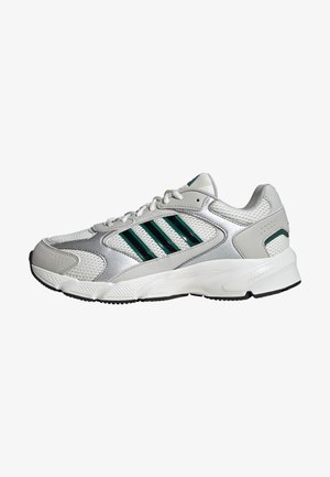 Weißer Sportschuh mit einem Obermaterial aus Mesh, metallischen silbernen Akzenten, drei grünen Streifen und einer strukturierten Gummisohle. Cloudfoam-Technologie.