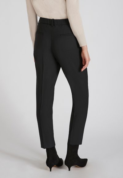 Czarne, dopasowane spodnie o zwężającym się nogawce, charakteryzujące się gładką fakturą, dyskretnymi kieszeniami z tyłu oraz paskiem w talii.
