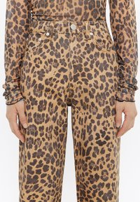 Lepelprint denim broek in lichtbruin en zwart, met een hoge taille, vijf zakken en een metalen knoopsluiting.