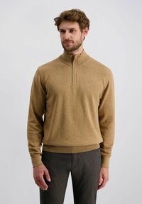 Lichtbruine pullover met rits en lange mouwen, geribde manchetten en zoom. Zachte textuur, minimale stikseldetails en een klassieke silhouet.