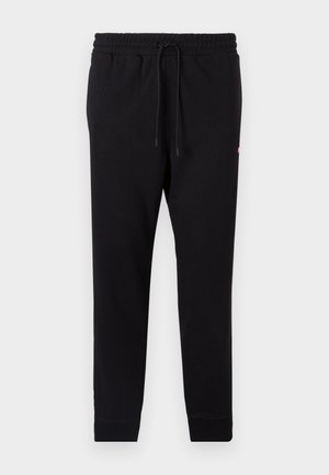 Black sweatpants made of soft fabric, featuring an elastic waistband with drawstring, tapered legs, and ribbed cuffs.